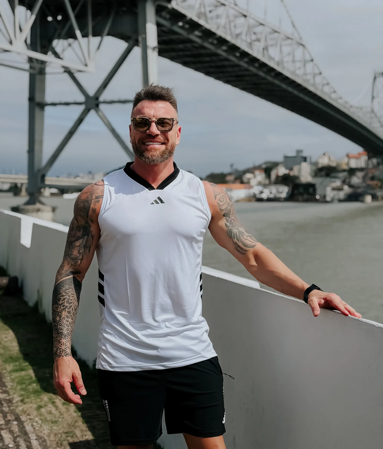 Regata dry-fit branca, fotografada pela Look Fit na beira-mar, com a ponte ao fundo